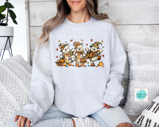 Person wearing a light gray sweatshirt with cartoon bear design sitting on a couch.