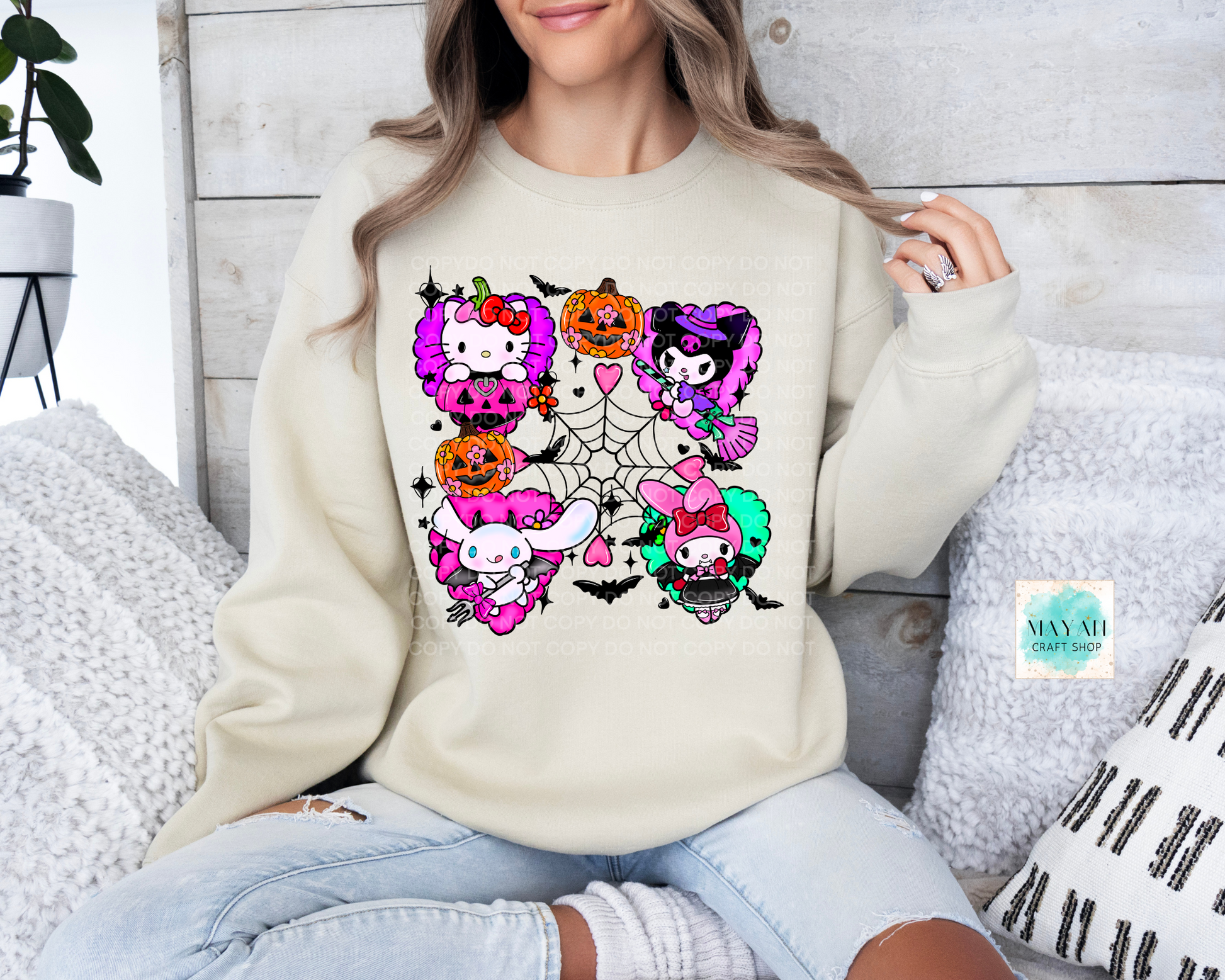 Person wearing a cream sweatshirt with colorful skeleton-themed designs sitting on a couch.