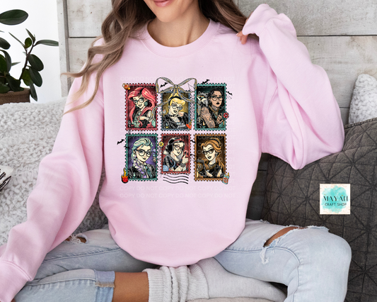 Person wearing a pink sweatshirt with graphic designs sitting on a couch.