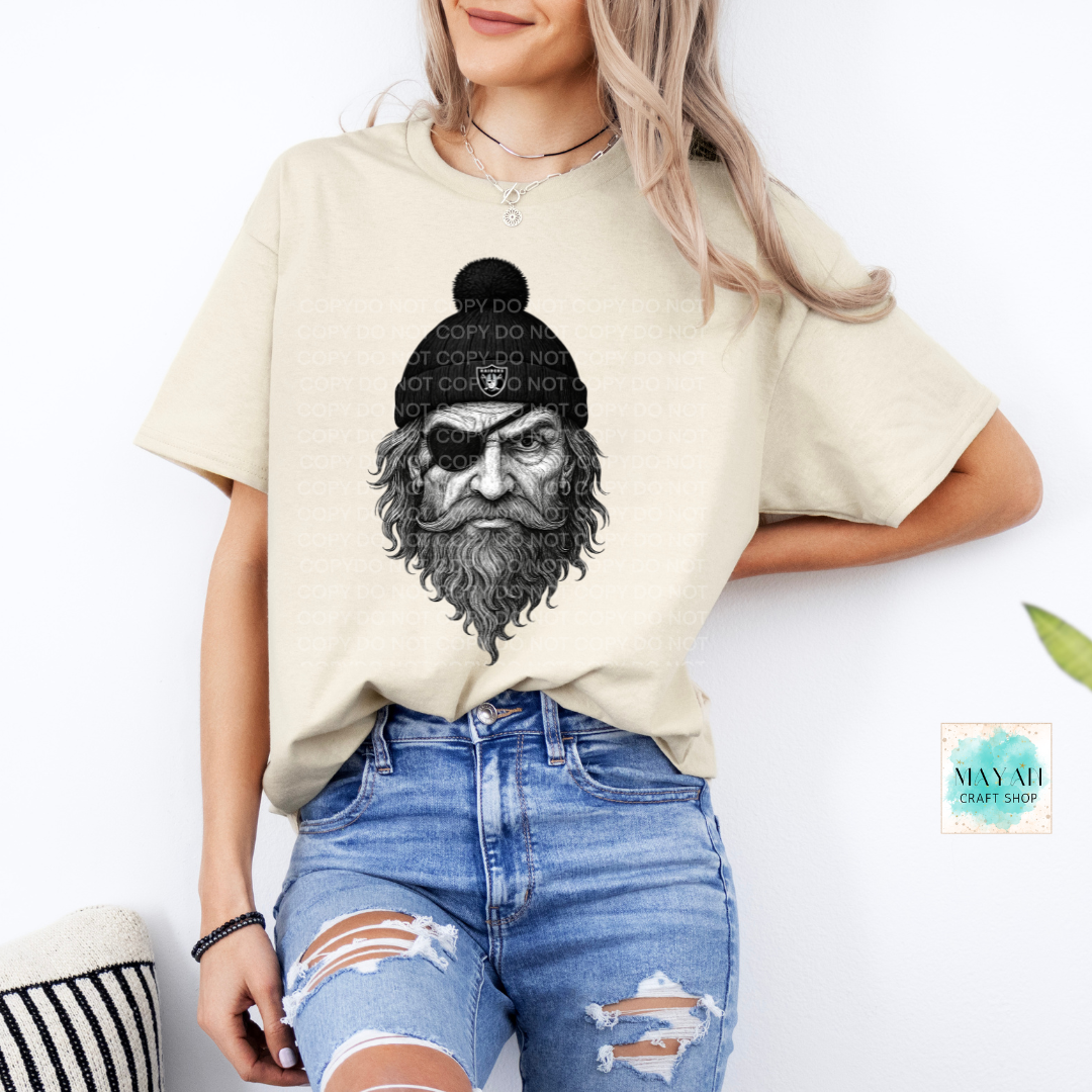 Person wearing a beige t-shirt with a graphic design of a bearded person in a beanie.