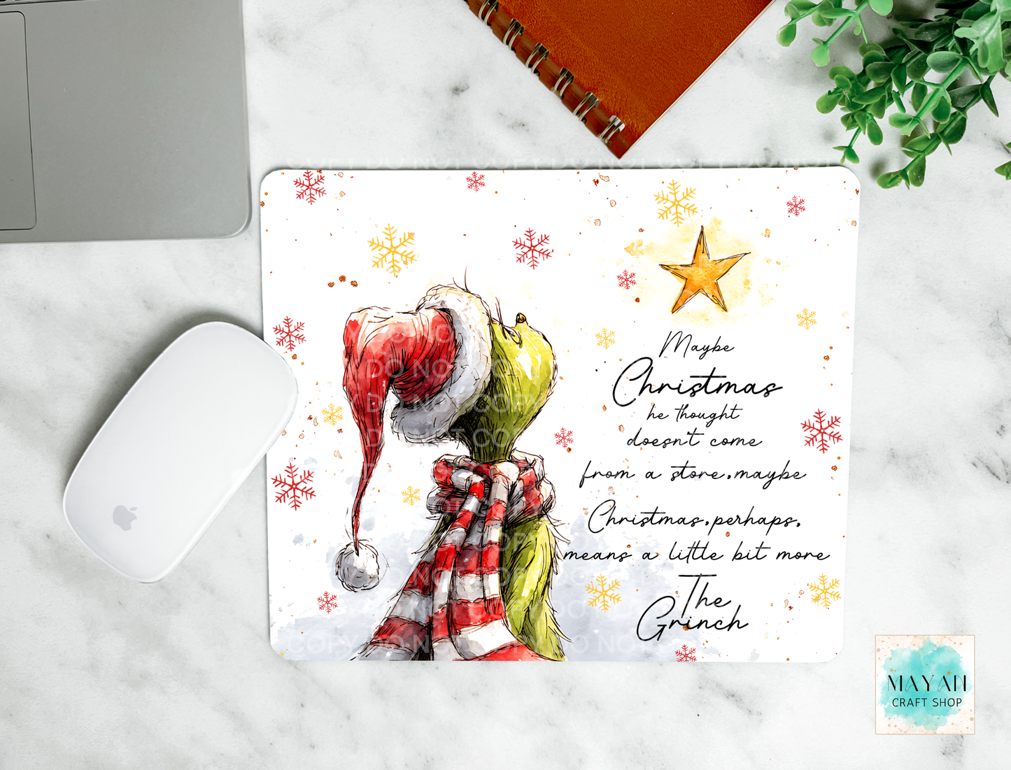 Christmas-themed mouse pad with text on a marble surface.