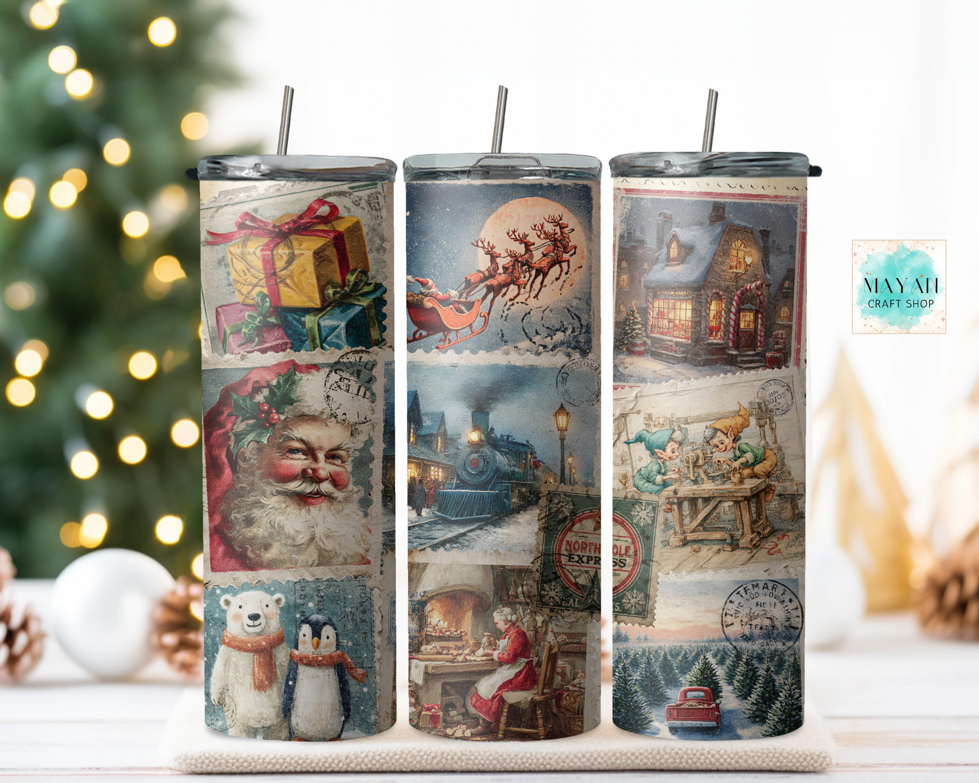 Three tumblers with Christmas-themed designs on a decorative stand with a blurred Christmas tree in the background.