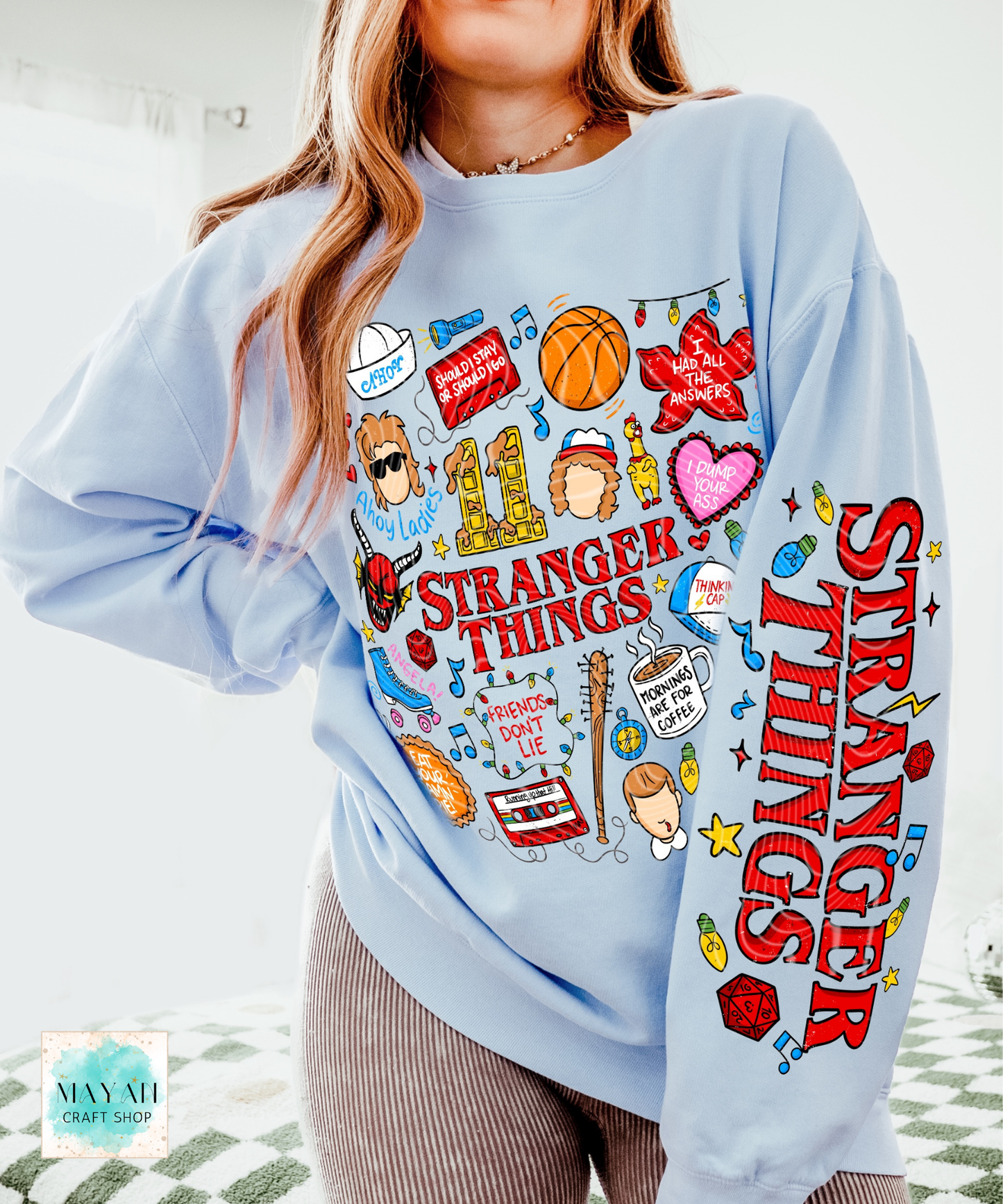 Light blue sweatshirt with doodles graphics worn by a person.