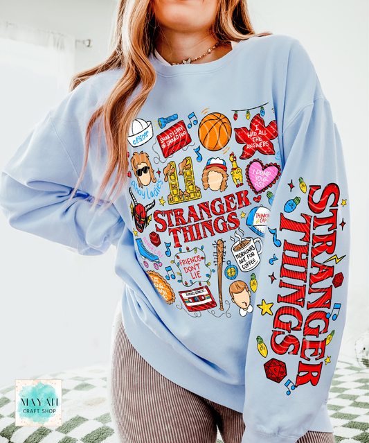 Light blue sweatshirt with doodles graphics worn by a person.