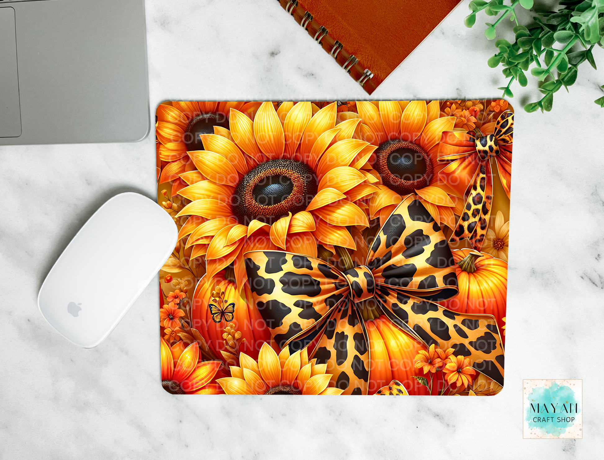 Decorative mouse pad with sunflower and leopard print design on a marble surface.