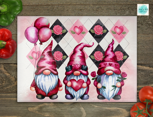 Three Valentine-themed gnomes with hearts and balloons on a decorative mat.