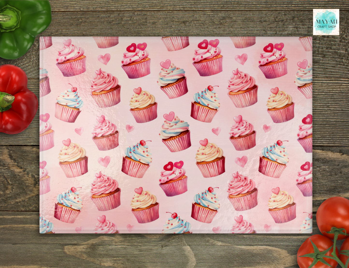 Cutting board with pink cupcakes on a wooden surface