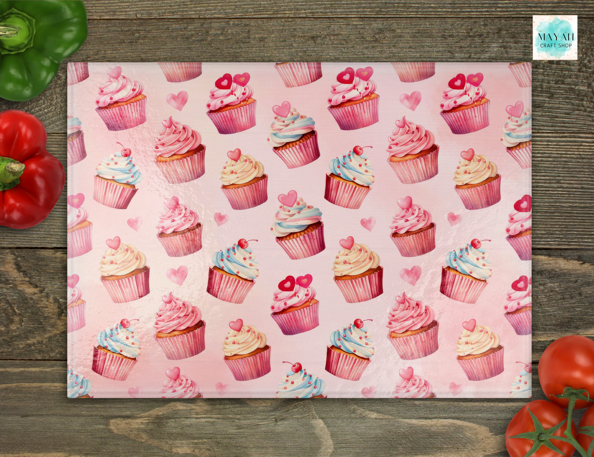 Cutting board with pink cupcakes on a wooden surface
