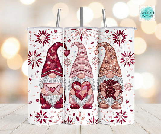 Three tumbler with gnomes and floral designs on a blurred background