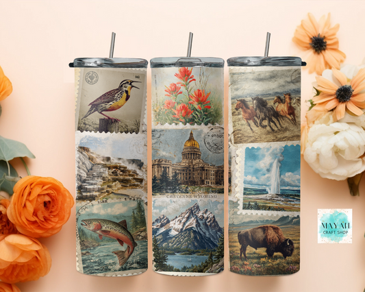 Three tumblers with scenic designs on a decorative background with flowers.