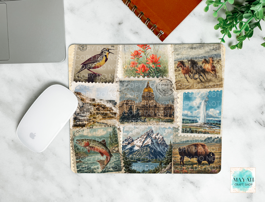 Mouse pad with vintage-style postage stamp designs on a marble surface.