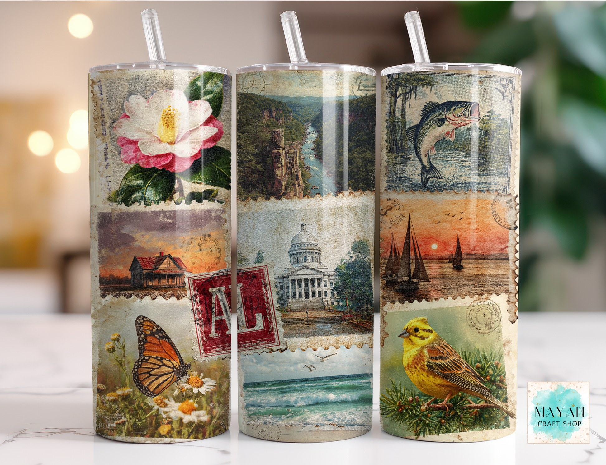 Three tumblers with scenic and nature-themed designs on a blurred background