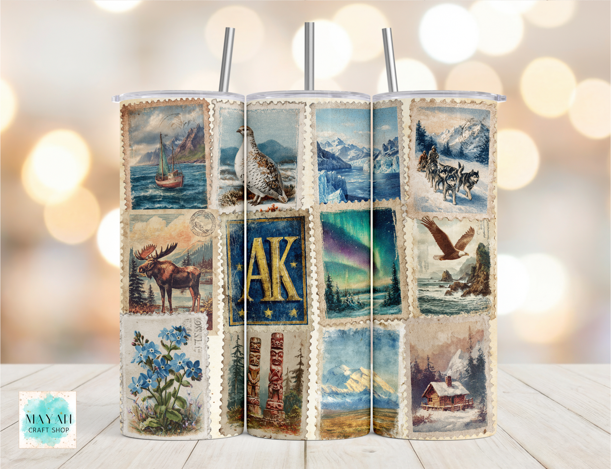 Tumbler with Alaska-themed design featuring various scenic and cultural images on a blurred background.