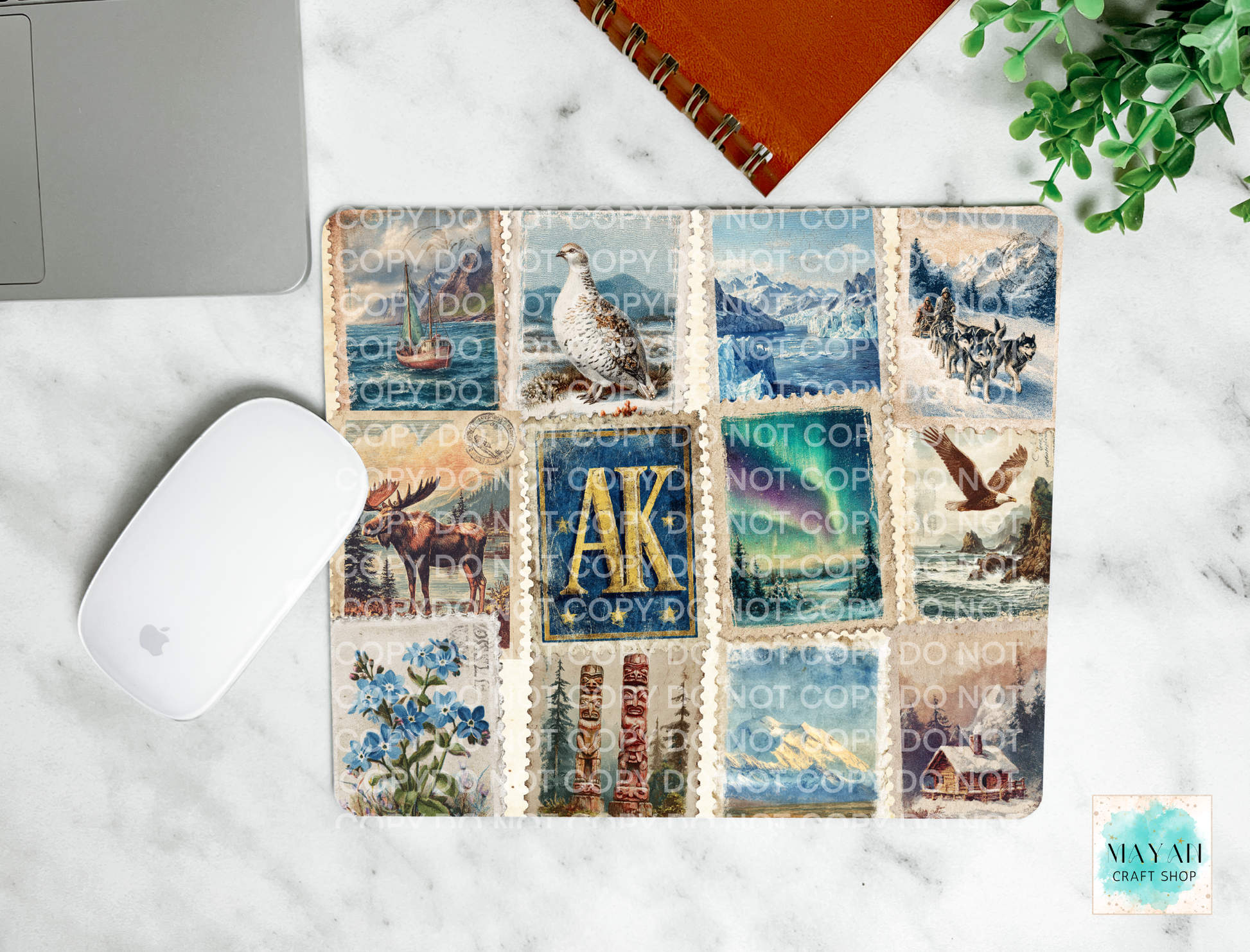 Mouse pad with a decorative case featuring stamps and nature-themed designs on a marble surface.