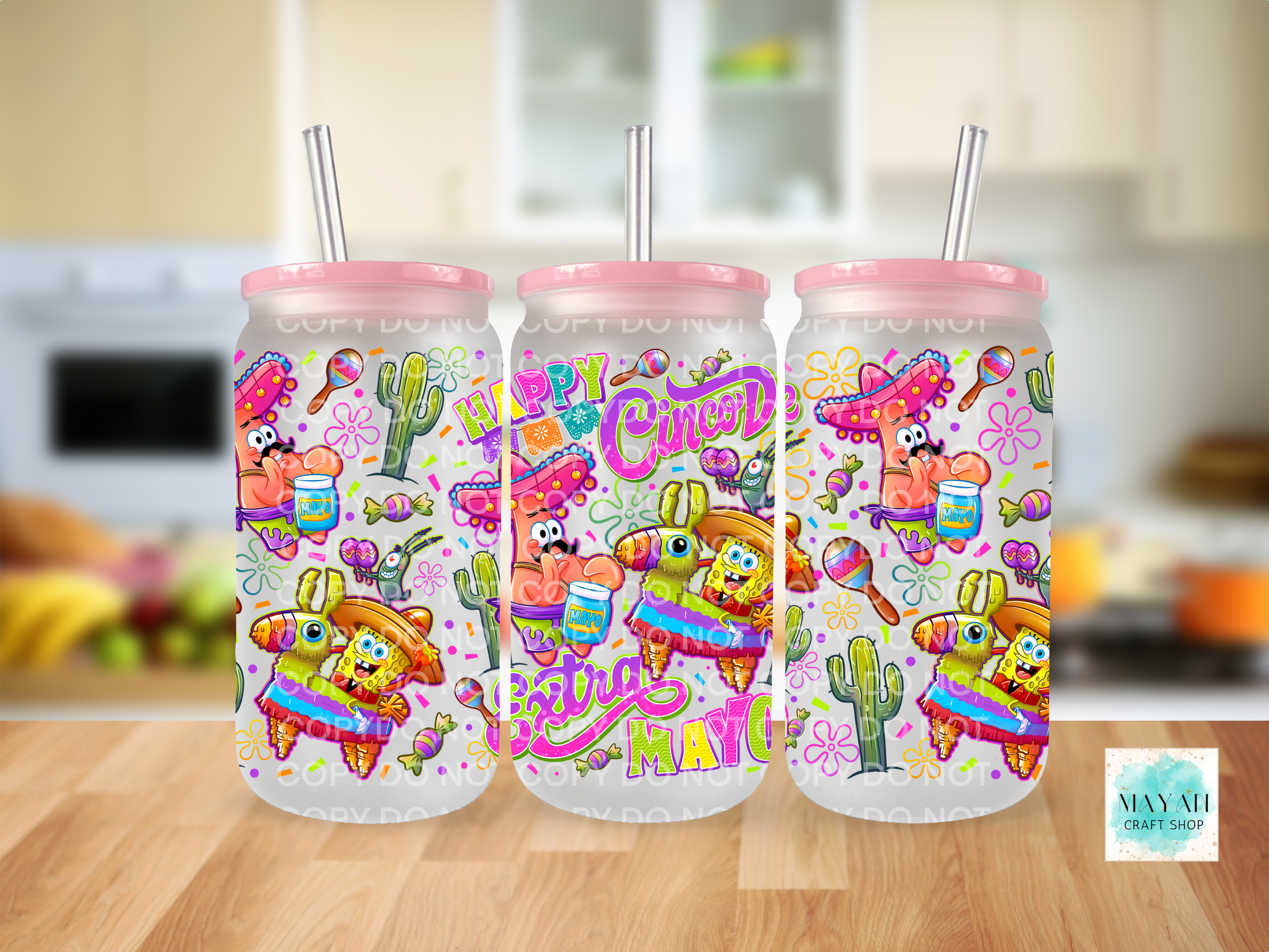 Three colorful tumblers with festive designs on a wooden surface.