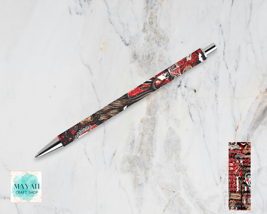 A decorative ballpoint pen with a detailed red, black, and gold dragon illustration, displayed diagonally on a white marble background. A close-up detail of the dragon pattern is shown in a vertical strip on the bottom-right.