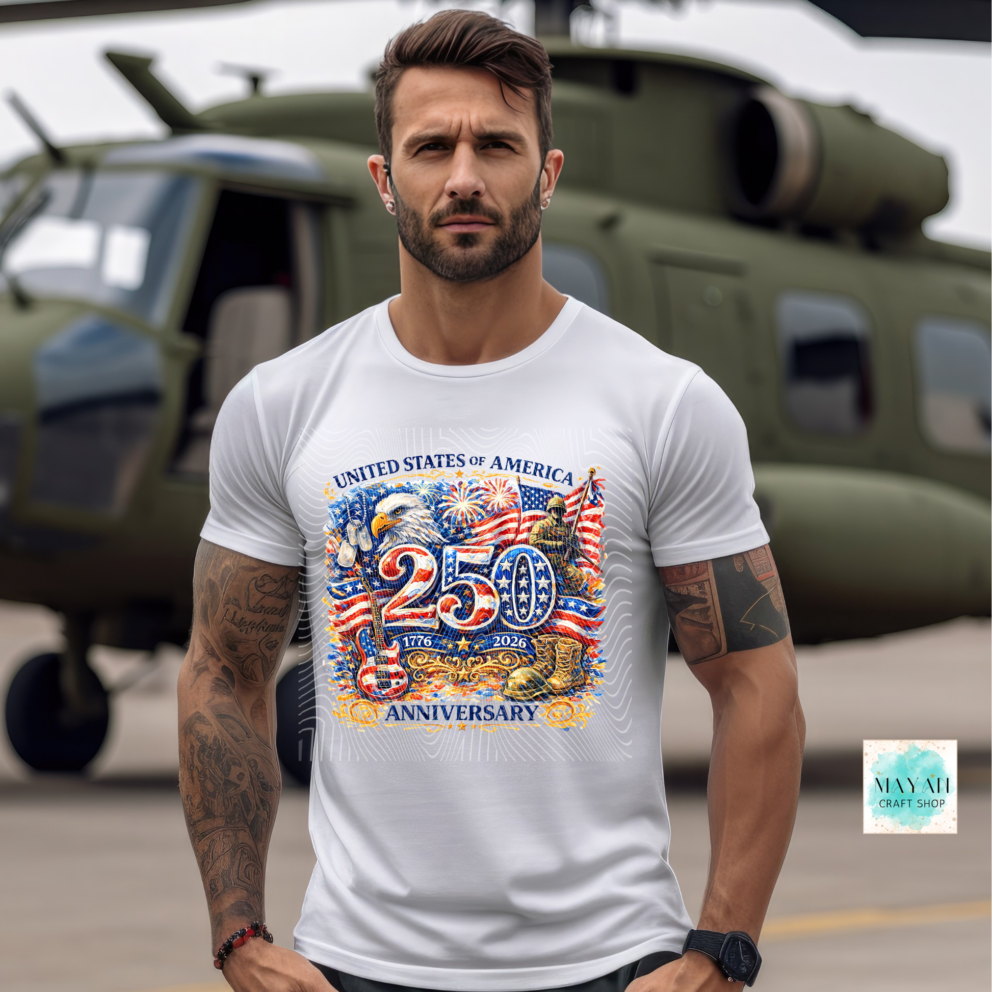 Man wearing a white t-shirt with a colorful graphic design in front of a helicopter.