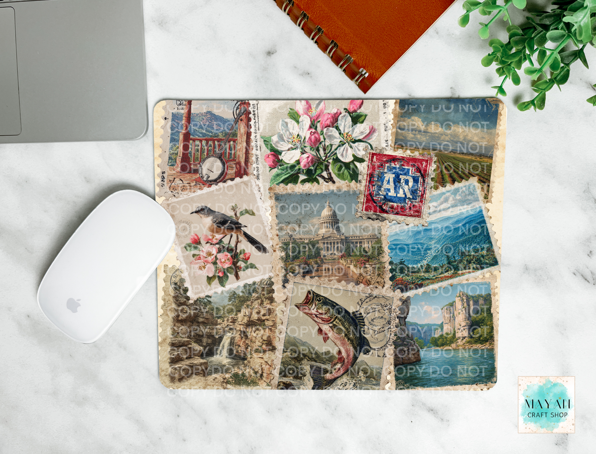Collage of vintage stamps on a mouse pad with a laptop and mouse in the background.