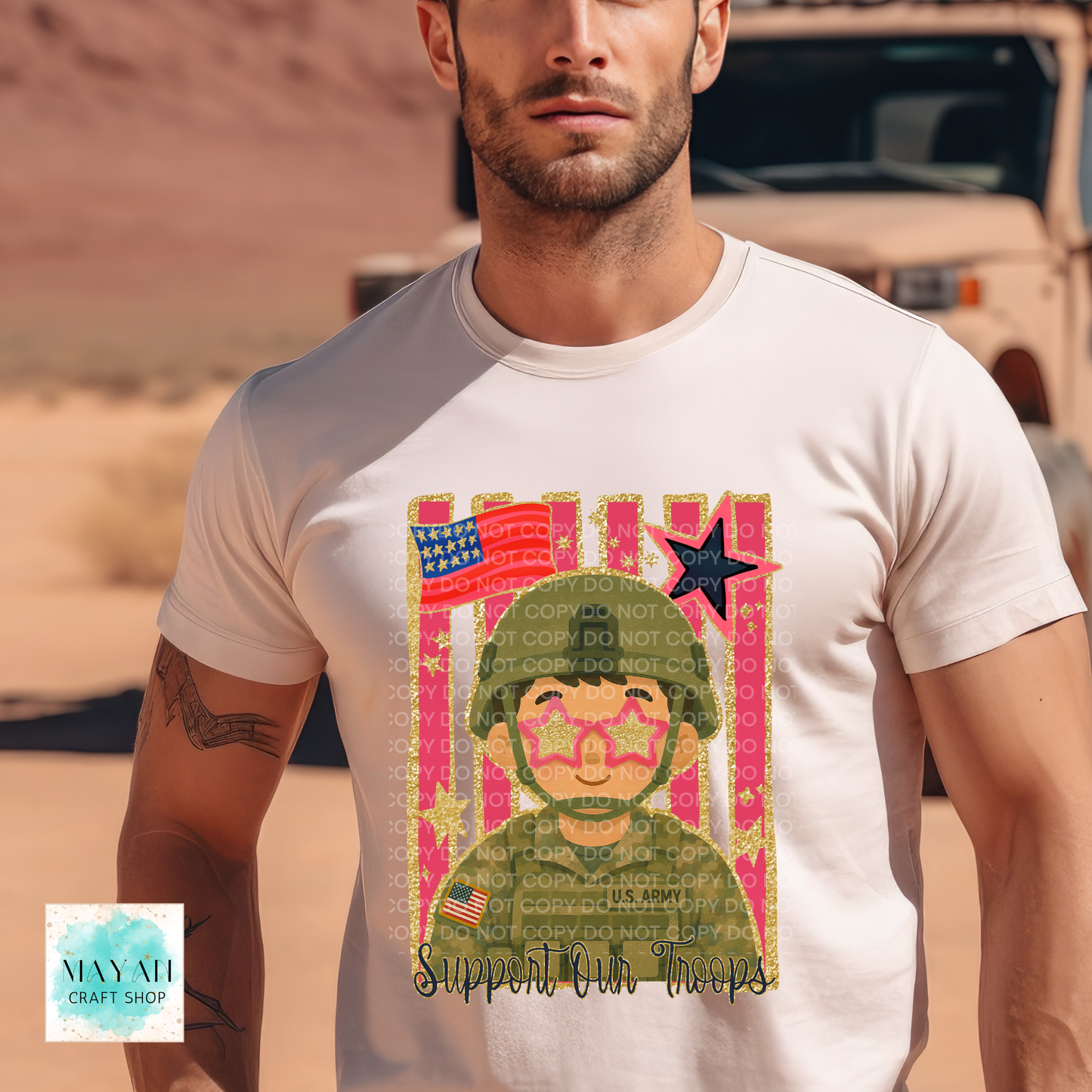 A man wearing a white t-shirt with a colorful graphic print of a soldier and the text 'Support Our Troops'. The background is a blurred desert landscape with a vehicle.
