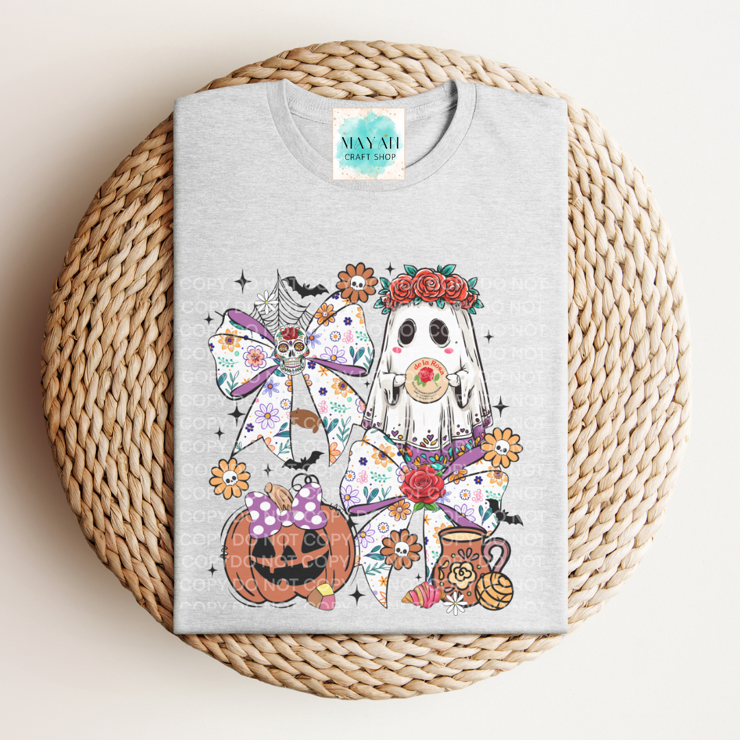 Gray t-shirt with Halloween-themed design featuring ghosts, pumpkins, and cats on a woven mat.