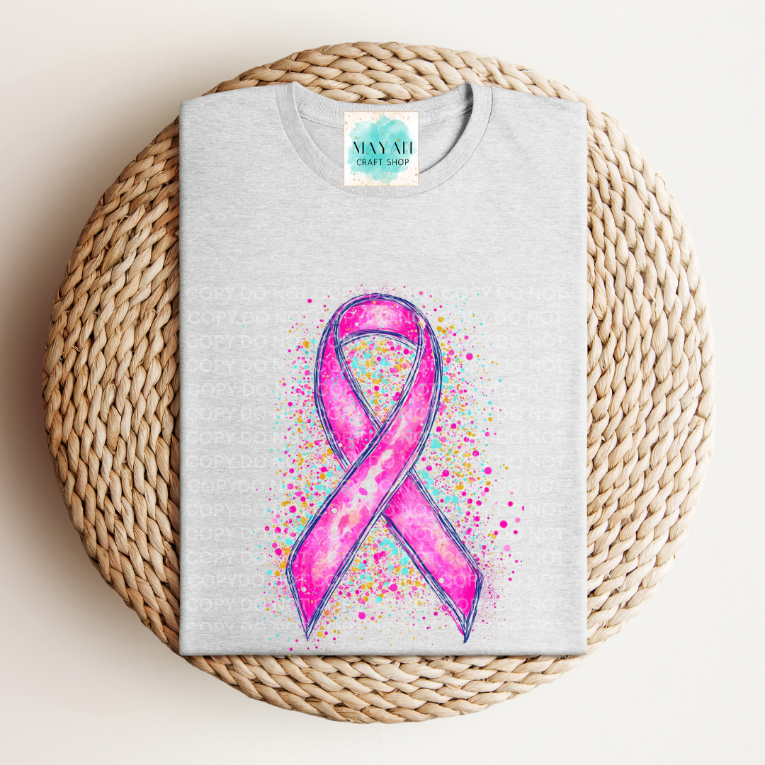 Gray tshirt with a pink ribbon design on a woven mat