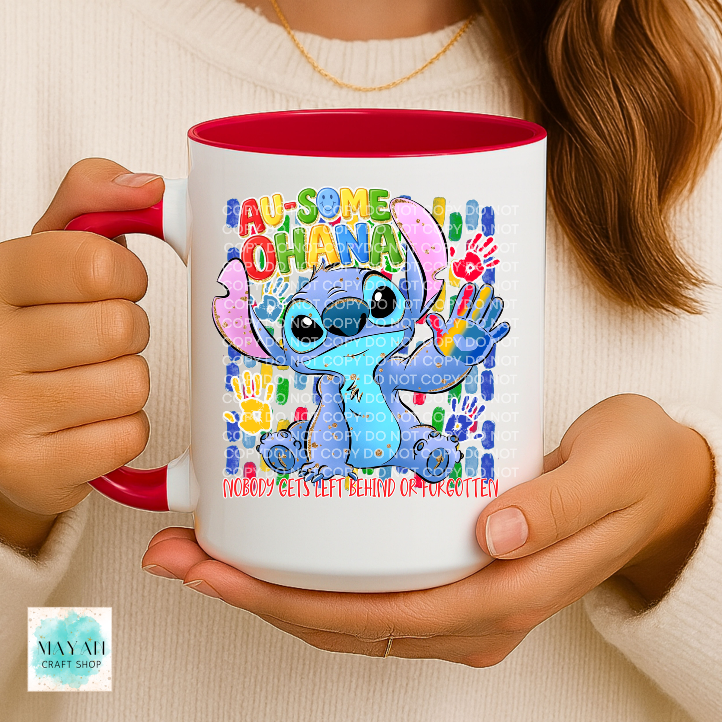 Person holding a mug with a colorful design featuring a character and text.