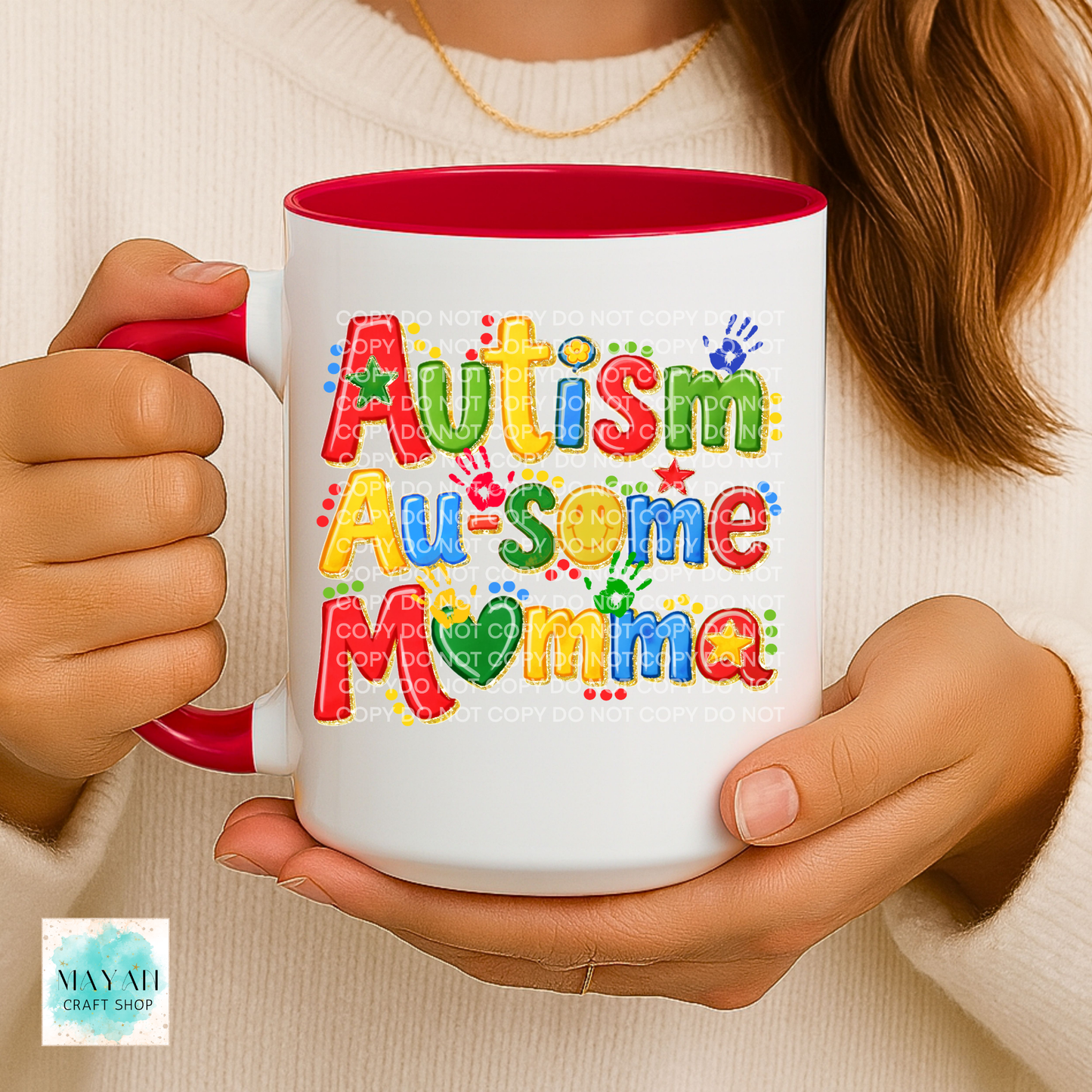 Person holding a mug with 'Autism Au-some Momma' text in colorful letters.