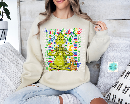 Person wearing a cream sweatshirt with a colorful graphic design sitting on a couch.