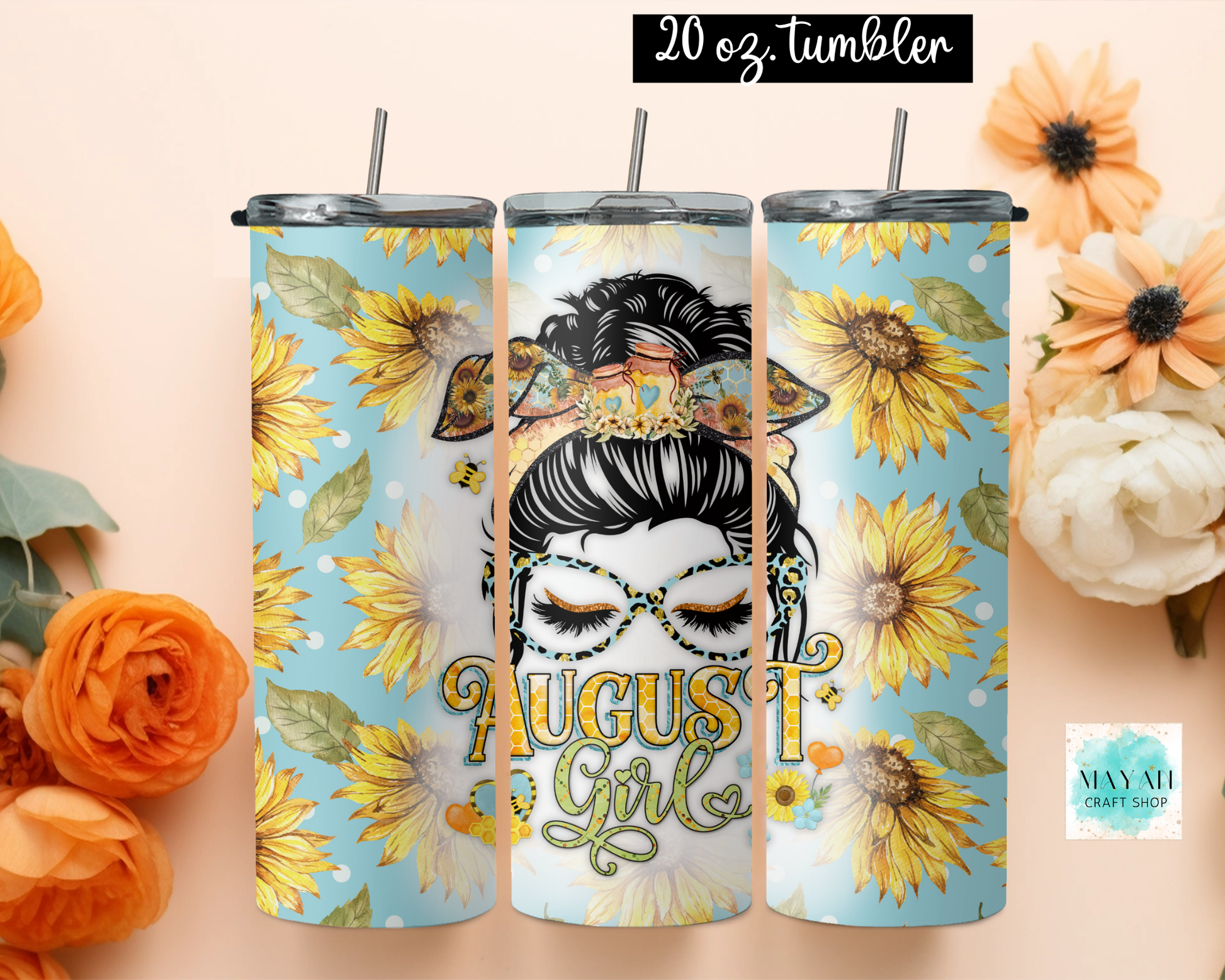 Three 20 oz tumblers with lids and straws displayed side by side on a peach background with decorative flowers. The tumblers feature a sunflower and bee pattern on light blue and white sections, with a central illustration of a woman's face in glasses and the text 'August Girl'.