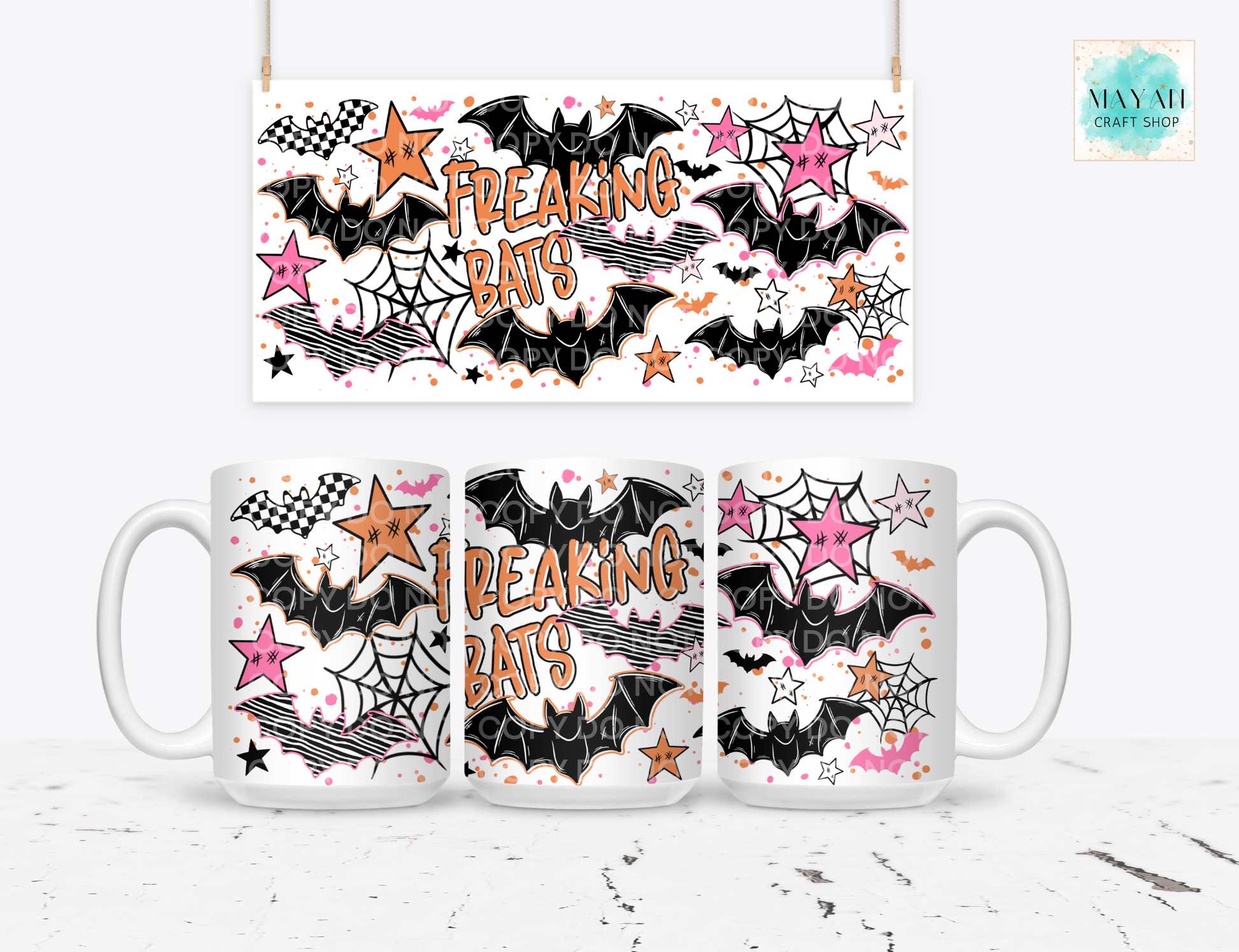 A white ceramic mug shown from three angles with a matching hanging banner above it, both printed with a Halloween-style design featuring black bats, pink and orange stars, spiderwebs, and the words “FREAKING BATS.”.