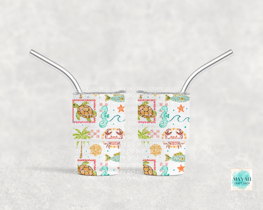 Two mini tumblers with metal straws on a white background, featuring sea-themed designs.