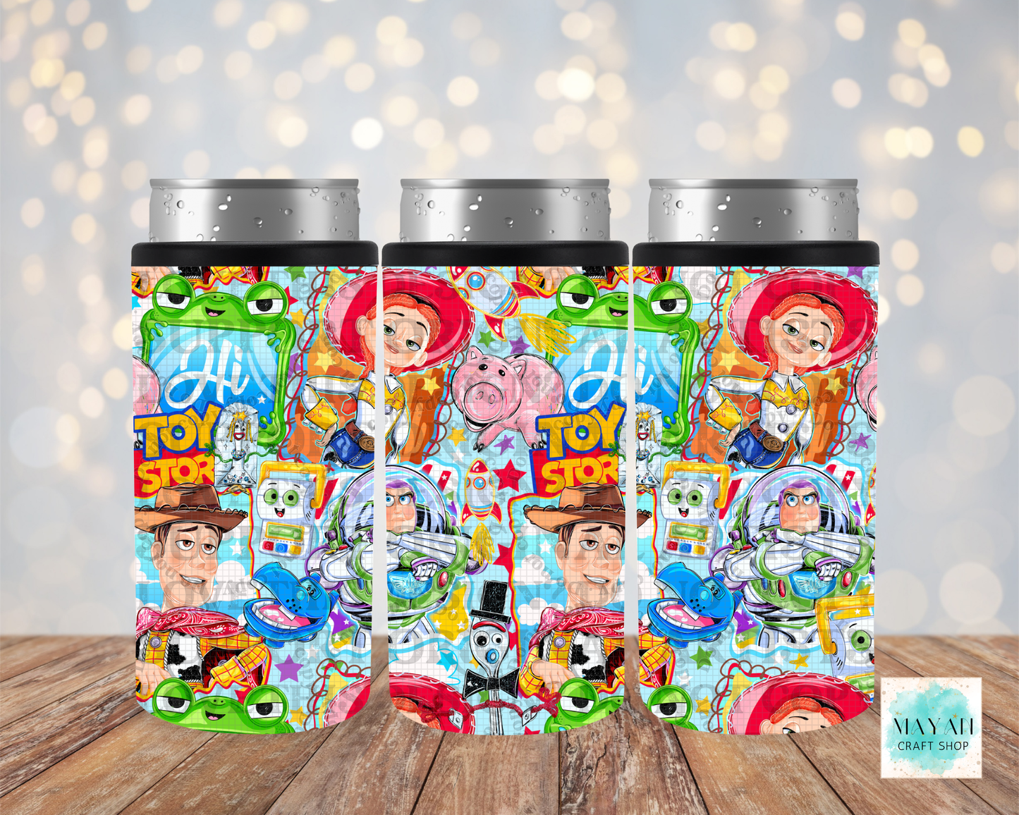 Three colorful tumblers with character designs on a wooden surface.