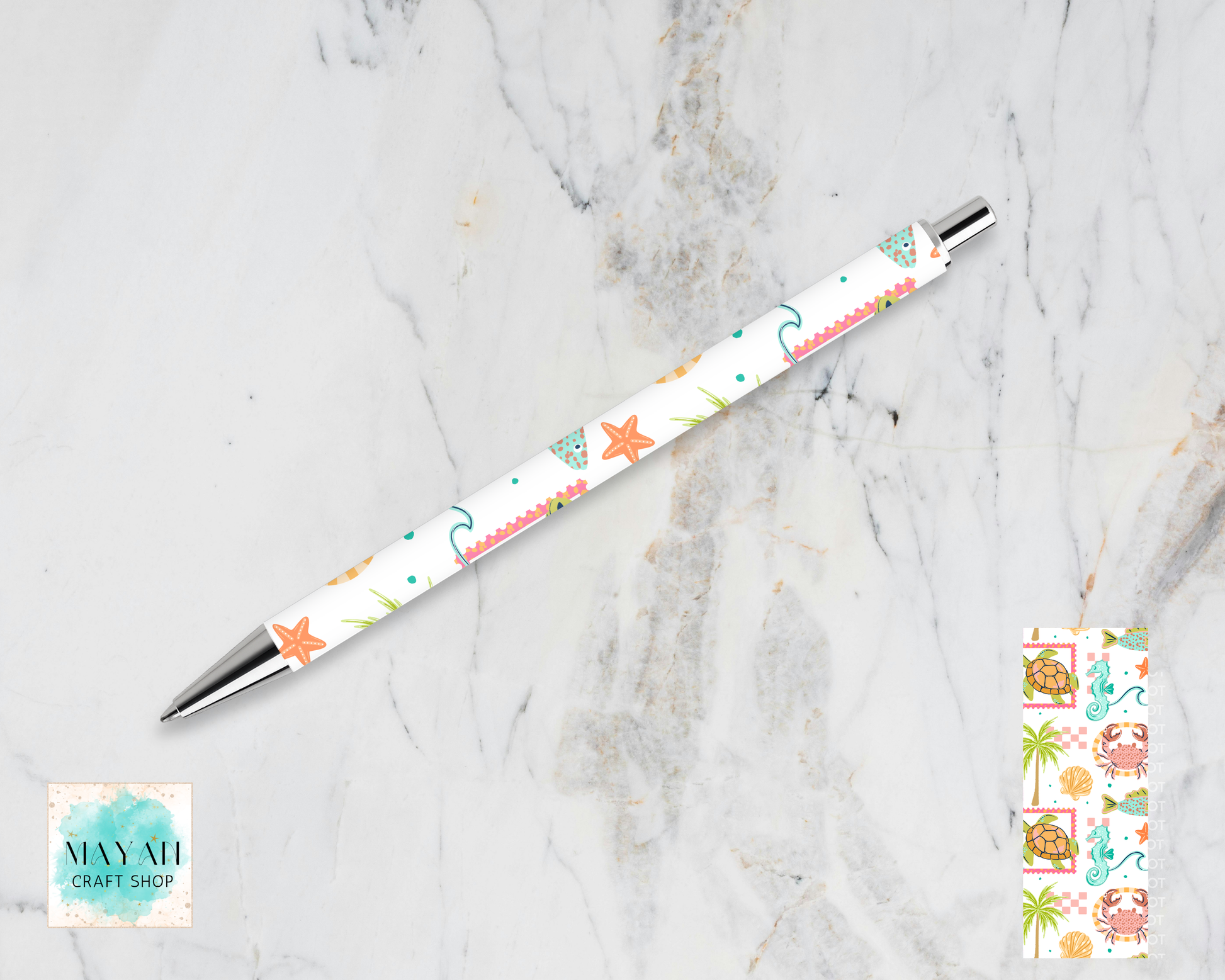 Decorative pen with starfish pattern on a marble surface, Maynil Craft Shop logo visible.