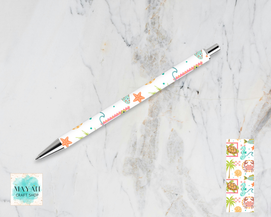 Decorative pen with starfish pattern on a marble surface, Maynil Craft Shop logo visible.