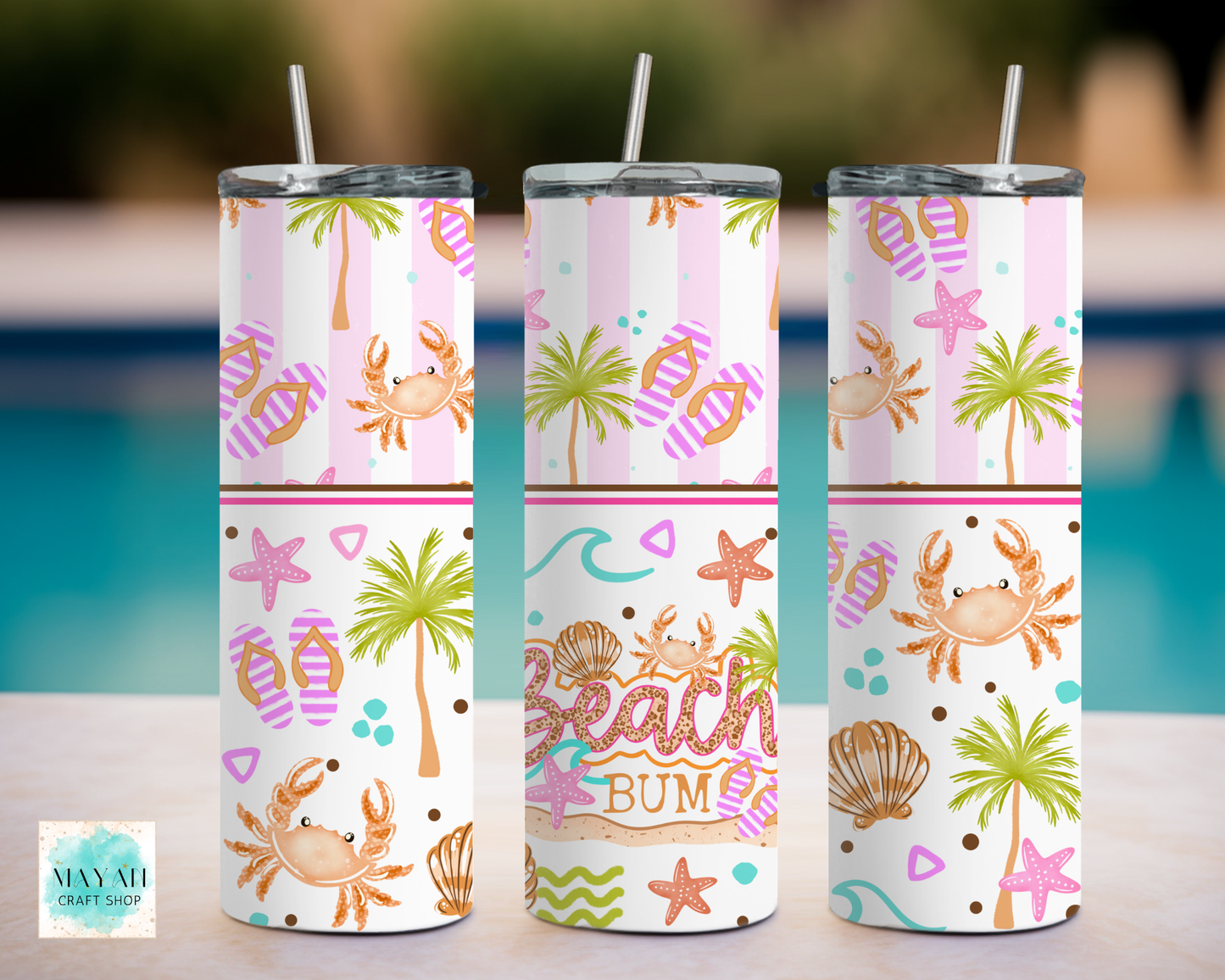 Three tumbler with beach-themed designs on a blurred outdoor background