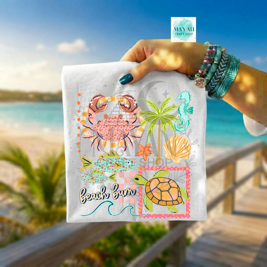 Hand holding a shirt with beach-themed designs against a beach background