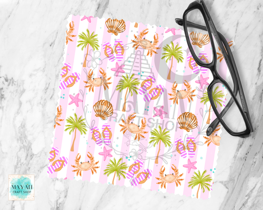 Colorful beach-themed lens cloth cleaner with palm trees, shells, and crabs on a marble surface.