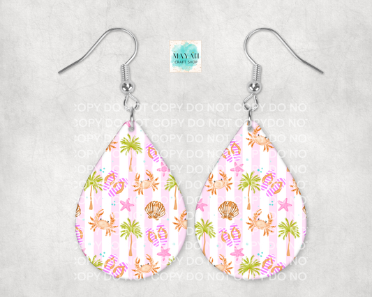 Teardrop-shaped earrings with a tropical pattern on a light gray background