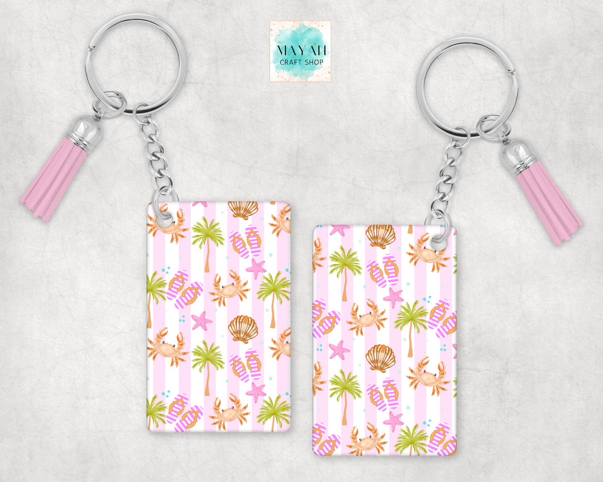 Two keychains with a tropical pattern on a light gray background