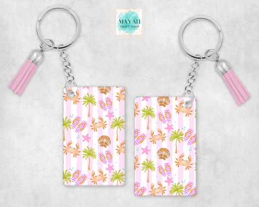 Two keychains with a tropical pattern on a light gray background