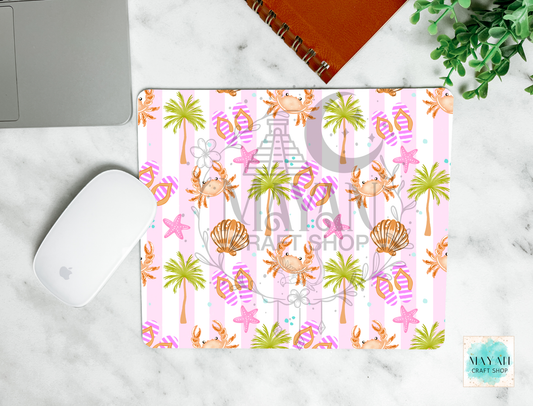 Colorful beach-themed mouse pad with palm trees, shells, and crabs on a marble surface.
