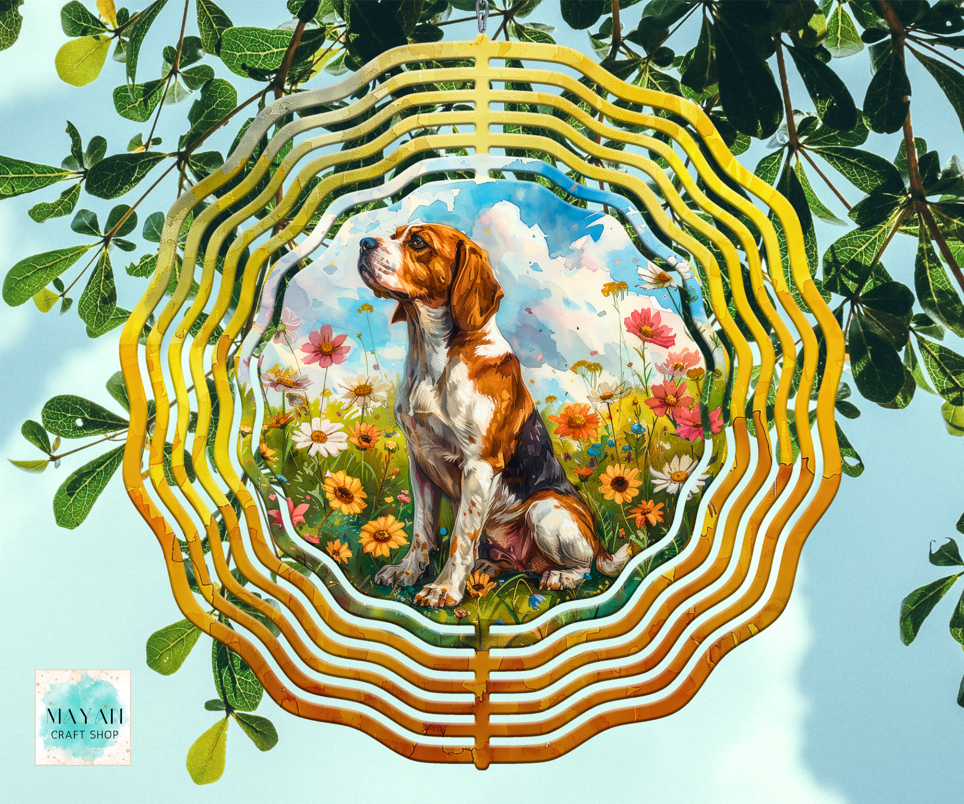 A wind spinner featuring a painted beagle dog sitting in a flower field, framed by concentric wavy gold-toned rings, shown against a light blue sky with green leaves.