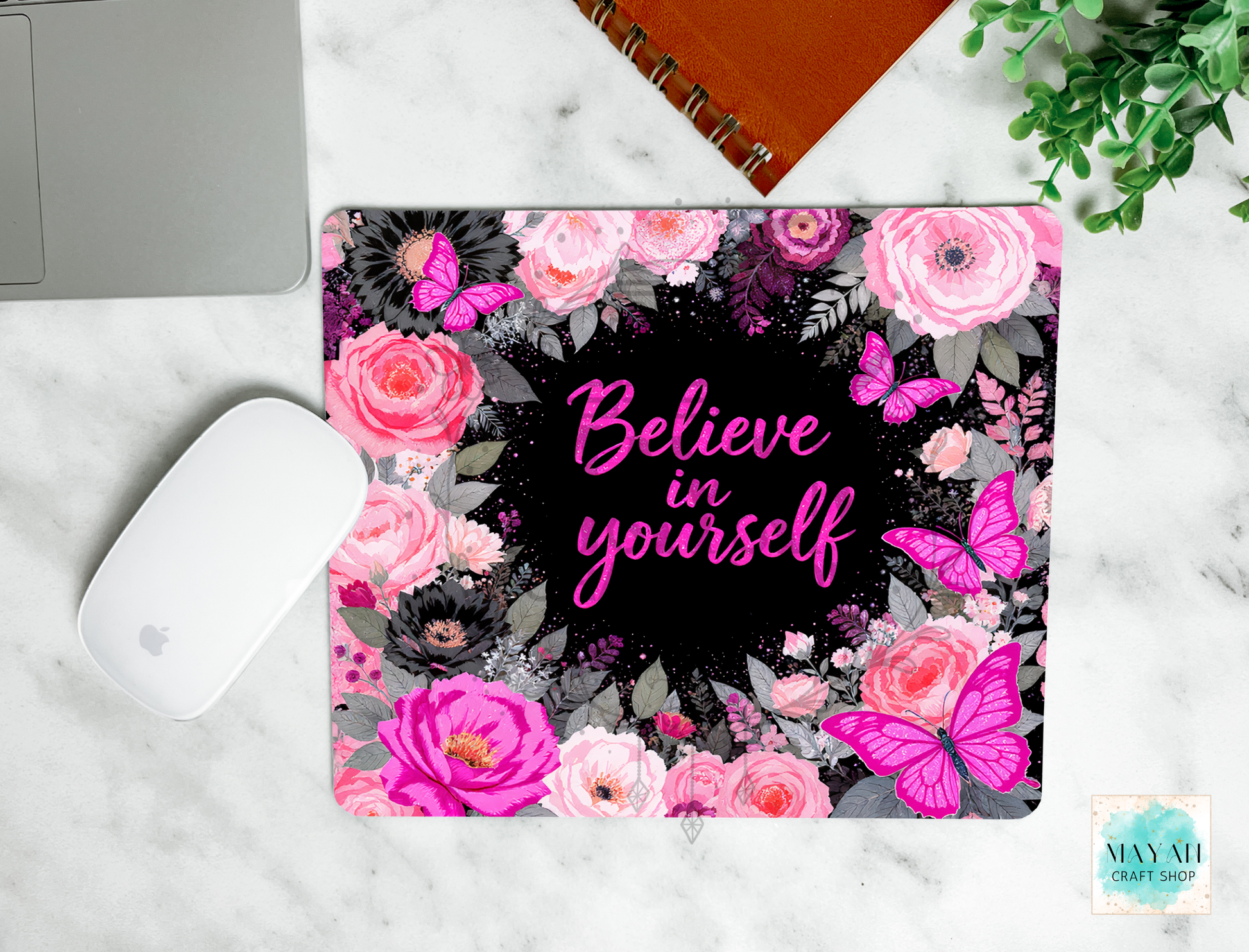 Floral mouse pad with 'Believe in yourself' text on a marble surface