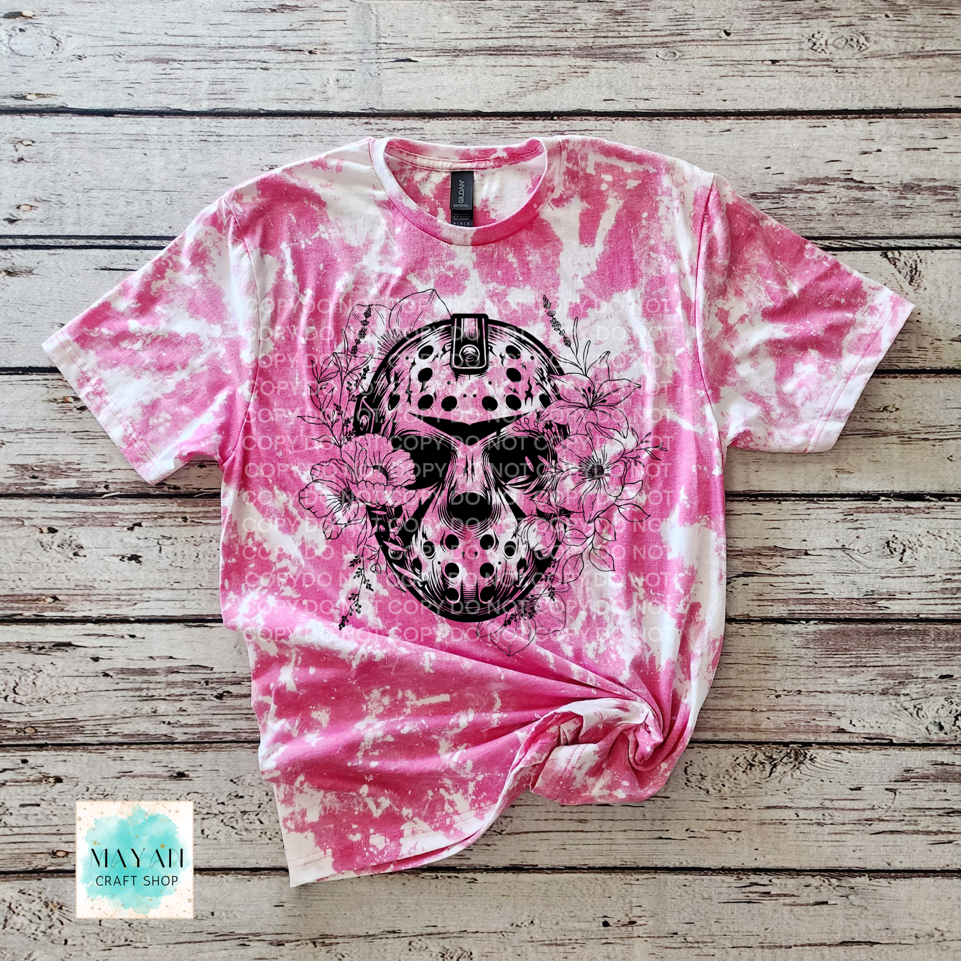 Pink tie-dye t-shirt with a black skull design on a wooden surface