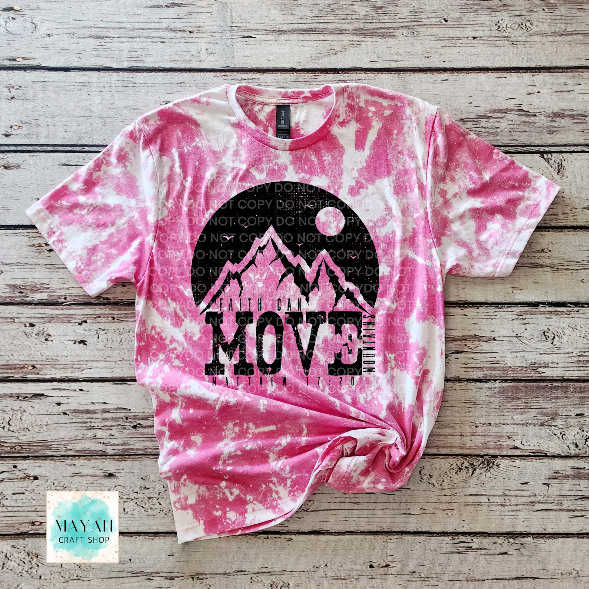 Pink tie-dye t-shirt with mountain graphic and 'MOVE' text on a wooden surface, brand 'Mayah Craft Shop' visible.