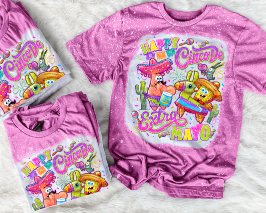 Pink t-shirt with 'Happy Cinco de Mayo' design featuring cartoon characters on a white background.