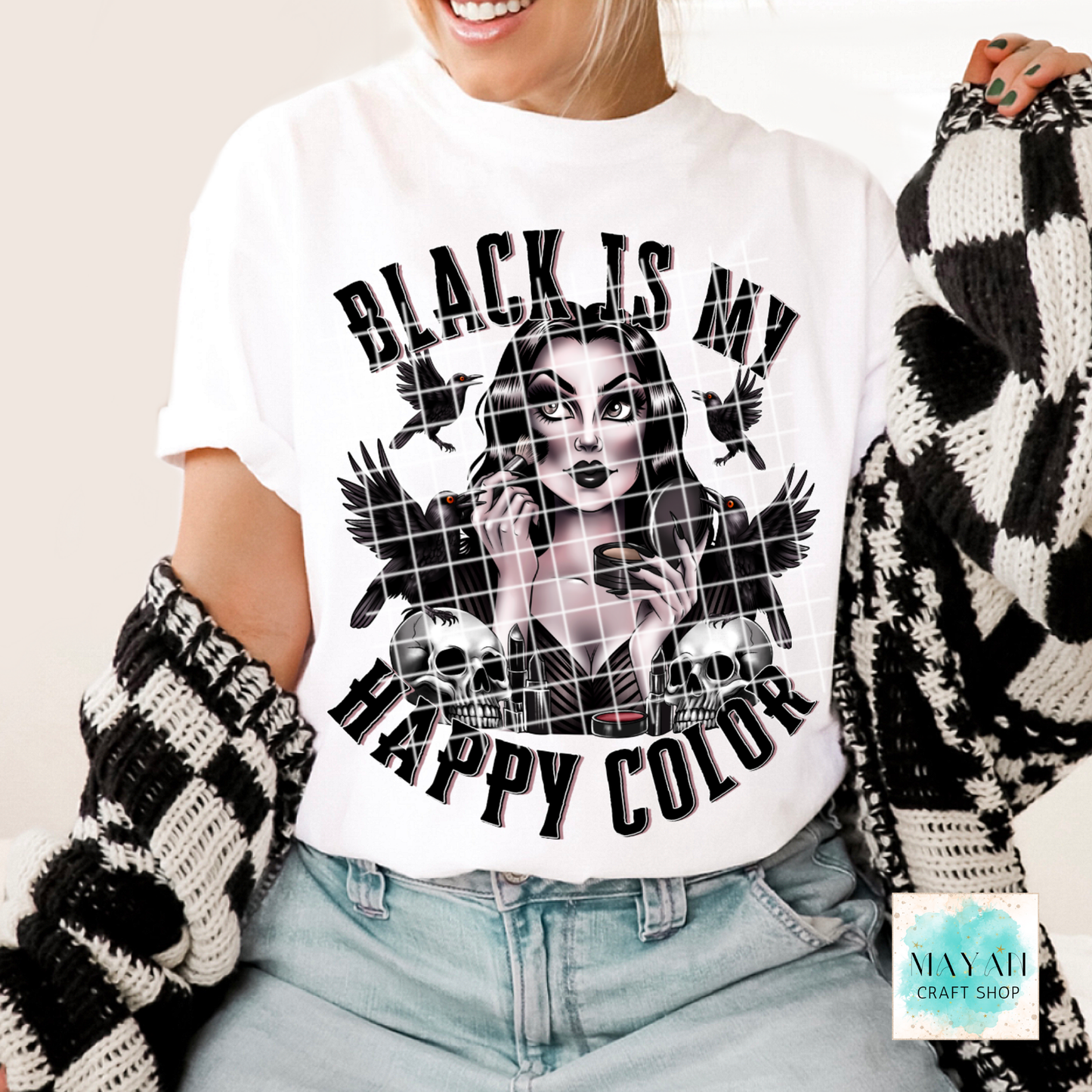 Person wearing a white t-shirt with a graphic design and text, holding a black and white patterned item.