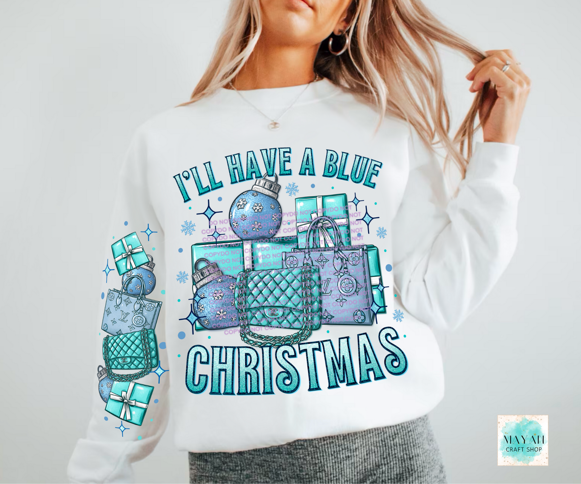 White sweatshirt with blue Christmas-themed graphics and text on a plain background