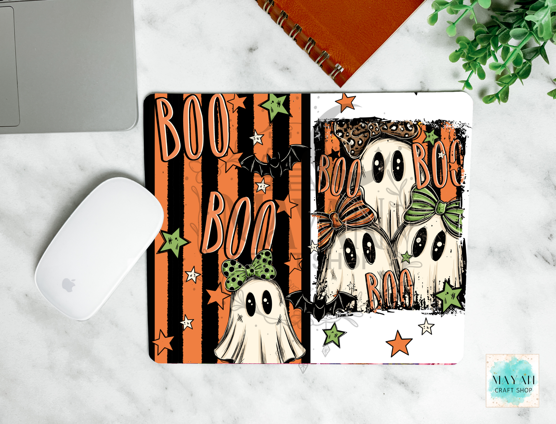 A mousepad with a Halloween design. The mousepad has a black and orange striped background on the left side with 'BOO' text and a ghost, and a white background on the right side with three cute cartoon ghosts wearing orange and green bows.