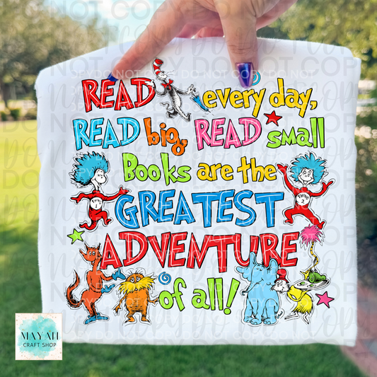 Hand holding a towel with colorful text and characters, promoting reading.